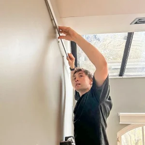Technician installing art hanging system